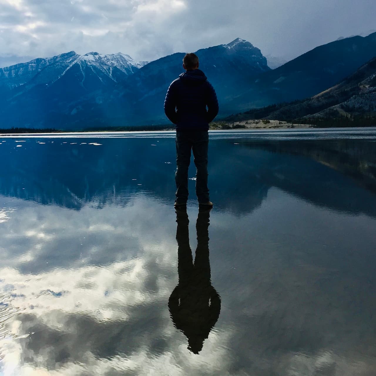 Gavin standing at the edge of a mountain lake